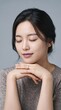 © mubashar - Serene Asian woman with eyes closed in peaceful meditation, beautiful young female portrait with natural makeup, elegant lady resting chin on hands
