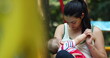 © Marco - Candid mother holding baby infant boy outside at park