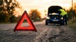 © md arif babu - Red emergency warning triangle on asphalt road, broken down car with open hood at sunset, roadside assistance and vehicle breakdown concept