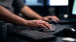 © Thares2020 - A person s hands carefully wiping down a keyboard and mouse on a dark desk with glowing computer screens in the background