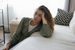 © BrightGridVisuals - Young adult woman with depression sitting at home alone