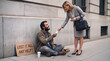 © ChaoticDesignStudio - Professional woman giving cash to homeless man on city sidewalk. Concept of charity, social inequality, and urban poverty.
