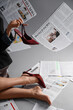 © Pixel-Shot - Legs of woman in high heels with many newspapers on grey background, closeup