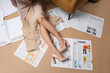© Pixel-Shot - Young woman in high heels with many newspapers sitting on brown background, top view