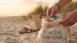 © Nina - Person collecting plastic waste in a canvas bag on a sandy beach during sunset, environmental conservation concept