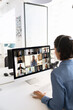 © fizkes - Customer support or office employee engage in remote video meeting displayed on computer monitor showing multiple colleagues connected from different locations. Communication, call, team collaboration