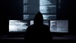 © Firadoaw - hacker sitting at desk with multiple monitors showing code and cyber attack interface