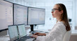 © Andrey Popov - Young Female Medical Scribe Reviews Clinical Notes On Laptop