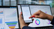 © Andrey Popov - Young Financial Analyst Studies KPI Dashboard On Smartphone