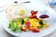 © BESTIMAGE - ix dish breakfast salad with fried egg, eggs Benedict, egg burrito, juice, toasted muffins, ham, poached eggs, and delicious buttery hollandaise sauce with fresh salad.