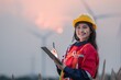 © BESTIMAGE - Industrial engineer inspecting wind turbine power generator sustainability performance inspection at Renewable Energy Plant Happy female worker using tablet for work at site during sunset