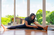 © Iryna - Yoga practice in a house with large windows and green surroundings during the day
