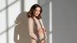 © Benjaporn - Pregnant woman portrait in neutral clothing against soft clean background showcasing maternal beauty emotional calm and refined motherhood wellness