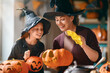© Konstantin Yuganov - Happy Family Halloween Pumpkin Carving at Home, Mother and Daughter