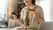 © Konstantin Yuganov - Happy Woman Shopping Online with Credit Card and Smartphone