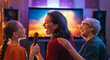 © Konstantin Yuganov - Joyful Multigenerational Family Singing Karaoke Together at Home in Cozy Living Room