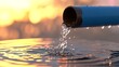 © MSTMAYA - Clear water flowing from a blue pipe into a container, creating ripples and splashes against a warm, golden sunset background, symbolizing water