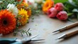 © Nataly - Floral arrangement tools with vibrant flowers including tulips and daisies on tabletop. Floral design tools are essential for creating beautiful flower arrangements.