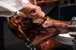 © planeta11 - experto jamonero manipulando un jamón ibérico quitándole la costra exterior
