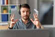 © Prostock-studio - Focused Man With Headset Engaged In Video Conference From Home Office, Expressing Emotions While Discussing With Colleagues. Sitting At Desk With Laptop In Modern Workspace. Business Concept.