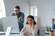 © Prostock-studio - Worried Hispanic Woman Looking Stressed At Computer Screen While Male Colleague Argues With Her At Workplace In Modern Office Environment. Business Concept.