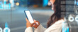 © Prostock-studio - Focused Unrecognizable Woman Engaged With Smartphone, Standing In Urban Setting At Night, Dim City Lights Illuminating Background. Modern Technology Concept In Daily Life.