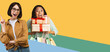 © Prostock-studio - Happy Young Women Smiling And Laughing Together While Holding Colorful Gift Boxes And Shopping Bags, Standing Against Bright Background. Joyful Moment In Shopping Environment, Celebration Concept.