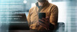 © Prostock-studio - Focused Unrecognizable Male Using Smartphone While Working On Laptop In Modern Office Environment, Engaged In Professional Tasks, Emphasizing Business Concept.