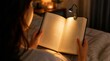 © Rosalia - Person reading book with clip-on lamp