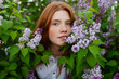 © Westend61 - Woman stands among blooming lilac bushes in the summer garden