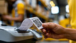 © Nataliya - Faceless hand holding printed receipt with QR code emerging from thermal printer in warehouse, barcode printing concept, logistics photography, blurred warehouse background, with
