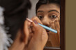 © IndiaPix - Kathak dancer applying makeup on her face.