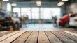 © Mari - Wooden tabletop in focus with blurred car dealership showroom in background, showcasing modern vehicles and spacious interior for product display.