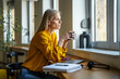 © Miljan Živković - Young woman relaxing coffee break looking through window