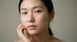 © Luz - Close-up portrait of a young Asian woman with glowing, natural skin looking directly at the camera, promoting beauty and skincare concepts.