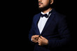 © Pixel-Shot - Handsome man in stylish suit with bow tie on black background