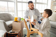 © Pixel-Shot - Father with his son assembling chair at home