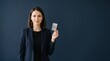 © Gabriel - Professional woman in suit holding a blank card against a dark blue background