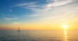 © Ionut - Small Generic Sailboat on Calm Open Water at Sunrise With Travel Copy Space