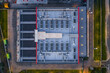 © AmazingAerialAgency - Aerial view of a modern datacenter roof featuring rows of HVAC cooling units, ventilation pipes, and industrial infrastructure, located in Settecamini, Lazio, Italy.