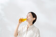 © naka - ペットボトルのお茶を飲む女性