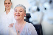 © Westend61 - Portrait of smiling senior woman at the eye doctor