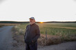 © Nazareno - Mature man standing in rural field contemplating sunset
