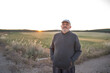 © Nazareno - Mature man standing in field at sunset enjoying nature