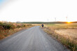 © Nazareno - Man hitchhiking on dusty country road at sunset