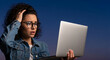 © Mirivox - Woman with glasses and curly hair holding laptop with worried expression, symbolizing stress, confusion, or frustration with technology