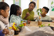 © Wavebreak Media - African teacher in green sweater with kids showing seed planting at class table with pots, tablet
