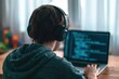© oksa_studio - Coder and programmer using a laptop for software development with audio headphones