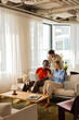 © Artem Podrez/Stocksy - Colleagues collaborating in modern office lounge