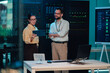 © Zamrznuti tonovi - It professionals discussing network management and data security in a server room, analyzing cloud computing operations